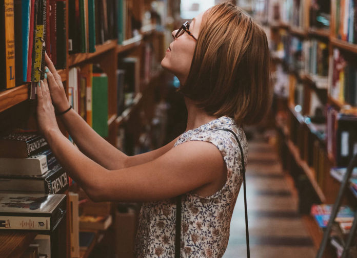 Female student browsing books in the library