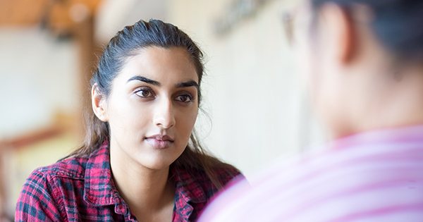 Female college student listens intently to another person.