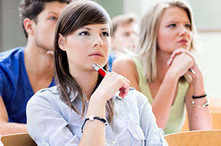 Female student intently listening during lecture.