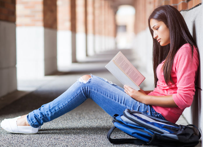 Female student studying in the hallway.