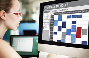 Female updates her weekly schedule on computer.